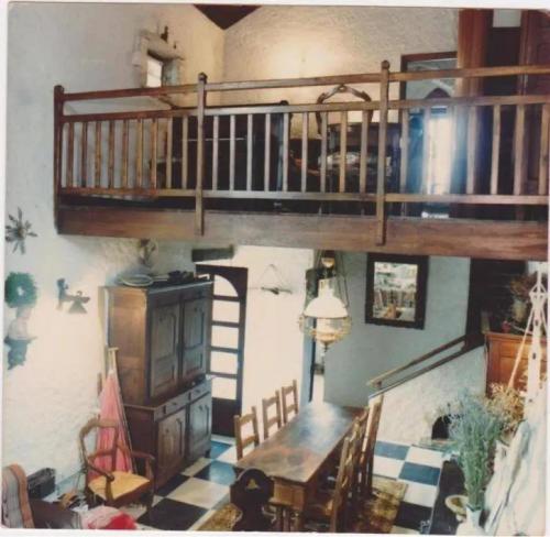 a living room with a loft bed and a table and chairs at Ancienne Chapelle du 12e siècle restaurée en maison de caractère sur falaise in Aiguèze