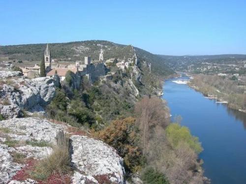a view of a river with a castle on a hill at Ancienne Chapelle du 12e siècle restaurée en maison de caractère sur falaise in Aiguèze