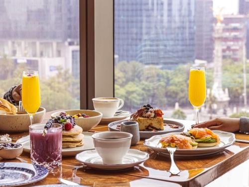 a table with plates of food and glasses of orange juice at Sofitel Mexico City Reforma in Mexico City