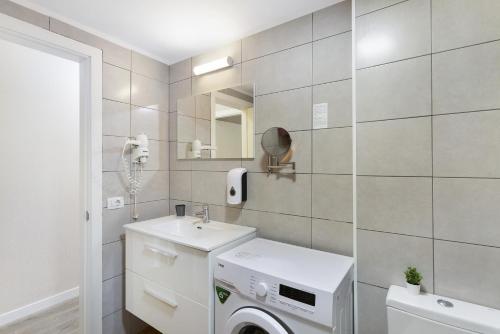 a bathroom with a washing machine and a sink at Enjoy in Puerto Rico de Gran Canaria