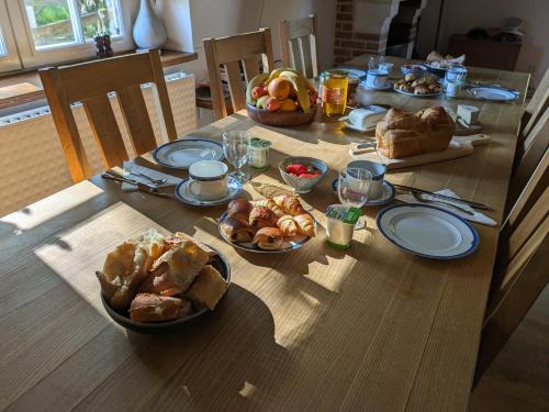 een houten tafel met borden met eten erop bij Le moulin Grenon in Mézilles