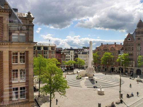 a city square with a fountain in the middle at Swissôtel Amsterdam in Amsterdam