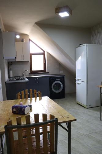 uma cozinha com uma mesa e um frigorífico branco em Lucy em Garni