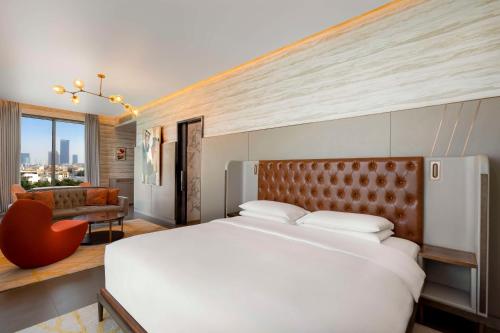 a bedroom with a large white bed and a chair at Hyatt Centric Jumeirah Dubai in Dubai