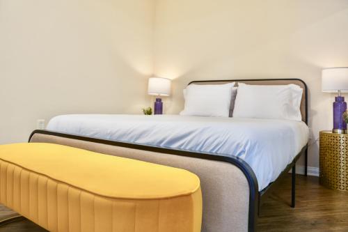 a bedroom with a bed and a yellow bench at Los Angeles Modern Studio in Los Angeles