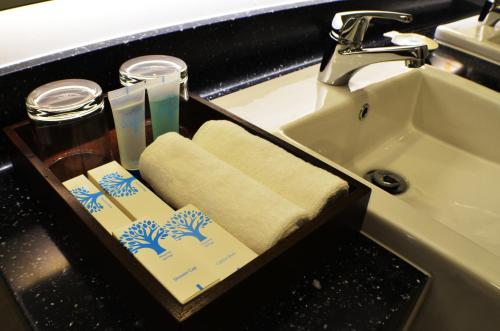 a bathroom with a sink and a towel holder next to a sink at H Boutique Hotel Sri Petaling in Kuala Lumpur