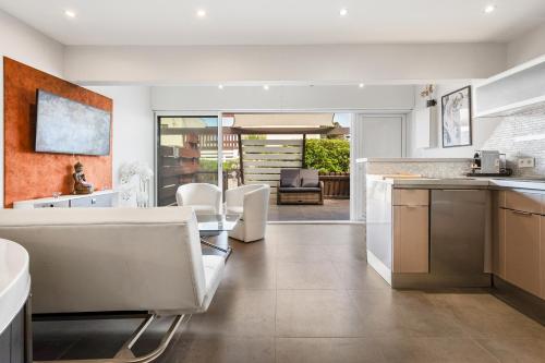 - une cuisine et une salle à manger avec des tables et des chaises blanches dans l'établissement Villa Jacuzzi Naturist Wifi Port Nature 1, au Cap d'Agde