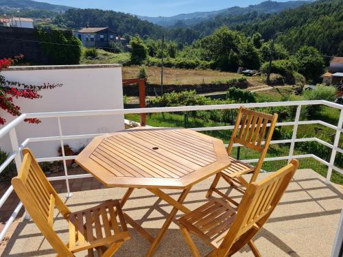 - Balcón con mesa de madera y 2 sillas en Coliving The VALLEY Portugal private bedrooms with a single or a double bed, a shared bedroom with a bed and futons, shared bathrooms and a coworking space open 24-7 en Vale de Cambra