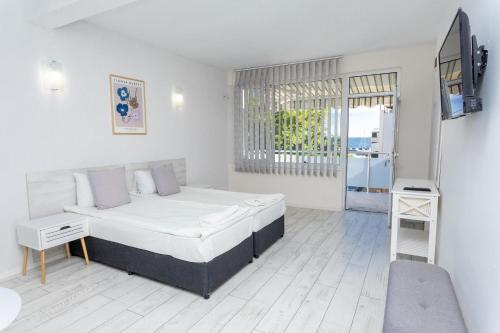 a bedroom with a bed and a tv in it at Guest rooms and apartments Desi in Balchik
