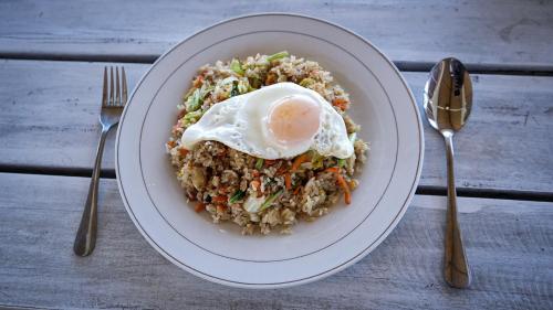 um prato de alimentos com um ovo em cima do arroz em Moyo Island Resort em Moyo Island