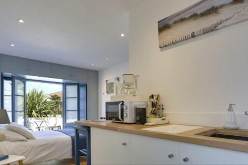 une cuisine avec un comptoir avec un micro-ondes et un lit dans l'établissement Cap Océan-Studio, à Capbreton