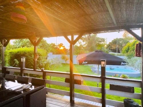 vista su un patio con ombrellone e piscina di Monte do Bidé Private Farm Peace and Nature a Setúbal