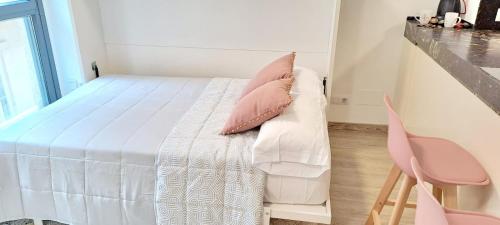 a bedroom with a bed and two pink chairs at Estudio centrico de lujo in Vigo