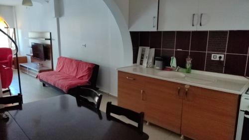 eine Küche mit einem Waschbecken und einem roten Sofa in der Unterkunft Sincer Otel in Kusadası