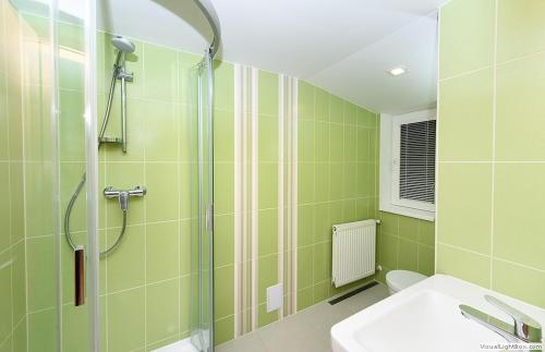 uma casa de banho verde com um chuveiro e um lavatório em Chata Cementár em Podhorie