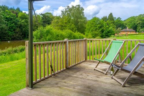 a deck with two chairs and a fence at Coot - Exton Park in Exton