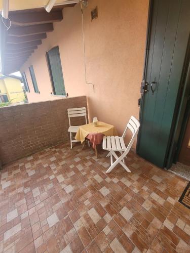 a patio with a table and two chairs and a door at Castelletto in Castello dʼAviano
