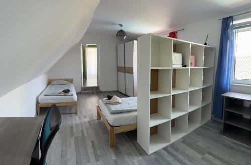 a room with a bed and a book shelf at Cozy Apartment next Outlet Center & Airport with Pool & Garden in Parndorf