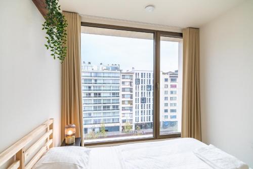 a bedroom with a bed and a large window at Opera Apartments in the Center of Antwerp in Antwerp