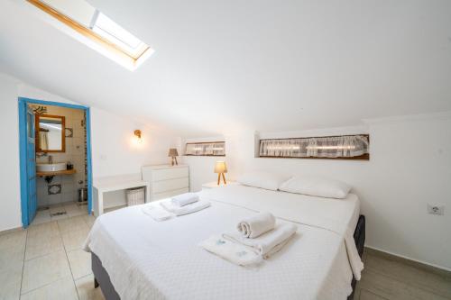 two beds in a white room with towels on them at Yoga House Kaş in Kaş