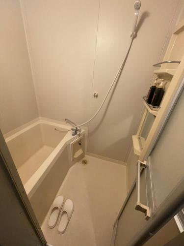 a pair of slippers in a bathroom with a shower at メゾンドリバージュ201 in Tokyo
