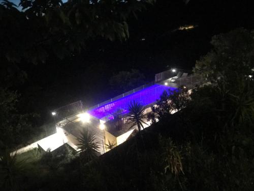 a building with purple lights on it at night at Gîte A Funtana Montestremo, Balagne, Haute Corse in Manso