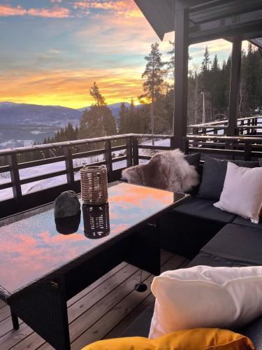 a living room with a couch and a table on a deck at Voss Resort self-service apartments in Skulestadmo
