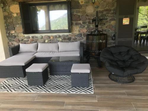 a living room with a couch and a chair at Gîte A Funtana Montestremo, Balagne, Haute Corse in Manso