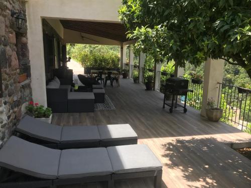 a patio with couches and tables on a wooden deck at Gîte A Funtana Montestremo, Balagne, Haute Corse in Manso