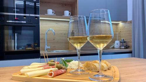 twee glazen witte wijn op een snijplank bij Apartments Cintya in Poreč