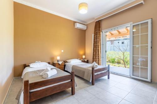 a hotel room with two beds and a balcony at Billo in Palaiochórion