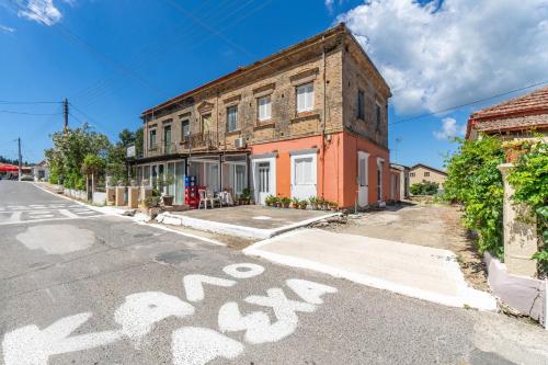 an old brick building on a street with a bike painted on the road at Billo in Palaiochórion