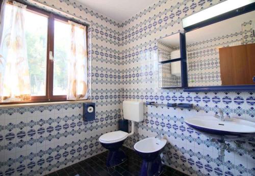 uma casa de banho com um WC, um lavatório e um espelho. em Apartment in Porec/Istrien 10068 em Poreč