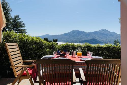 a table with glasses on it with a view of the mountains at Doris in Ghiffa