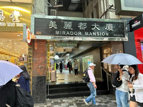 un grupo de personas con paraguas delante de una tienda en 3D Inn Hong Kong - Dragon, en Hong Kong