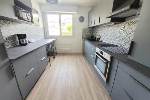 Il comprend une cuisine avec des placards gris et du parquet. dans l'établissement New and Splendid apartment in the heart of Vannes, à Vannes
