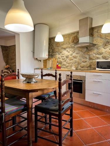 a kitchen with a wooden table and chairs at Casa da Fonte Grande - By Cabralina Apartments in Belmonte