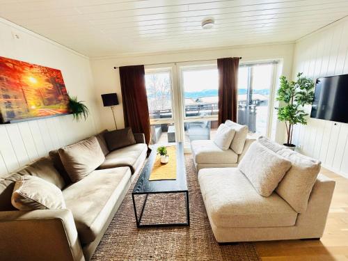 a living room with two couches and a tv at Voss Resort self-service apartments in Skulestadmo