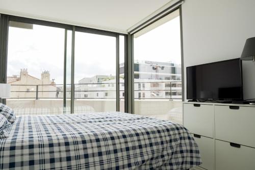 une chambre avec un lit, une télévision et des fenêtres dans l'établissement La Major du Sud proche Vieux-Port, à Marseille
