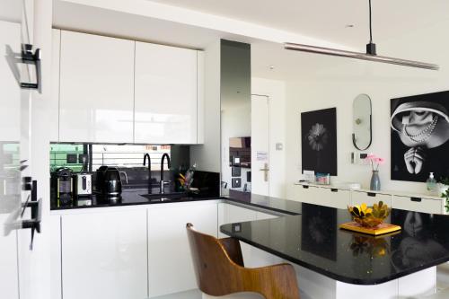 une cuisine avec des armoires blanches et un comptoir noir dans l'établissement La Major du Sud proche Vieux-Port, à Marseille