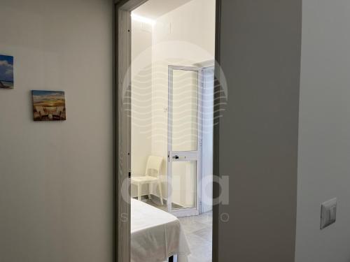 a glass door leading into a room with a table at Roma n 3 in Torre Lapillo