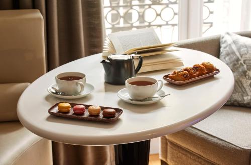 - une table avec deux tasses de café et des pâtisseries dans l'établissement Sofitel Paris Arc De Triomphe, à Paris