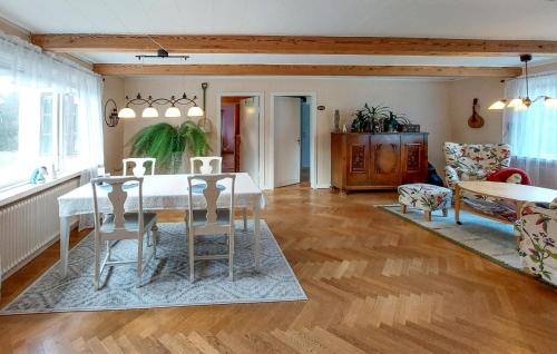 a living room with a dining room table and chairs at 3 Bedroom Awesome Home In Röke in Röke