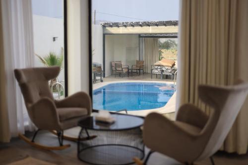 a living room with two chairs and a swimming pool at SS resorts in Hatta