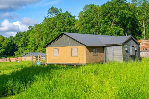 a small yellow house in a field of tall grass at Coot - Exton Park in Exton