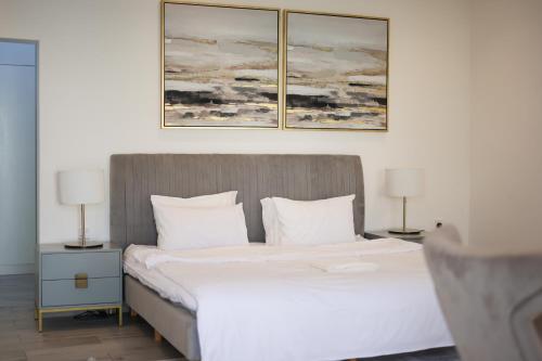 a bedroom with a bed with three paintings on the wall at SS resorts in Hatta