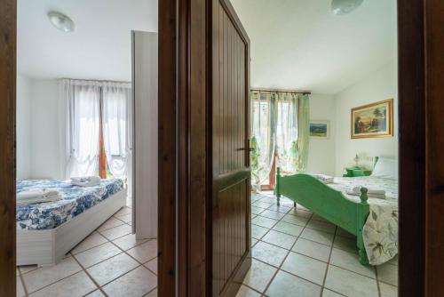 Un dormitorio con una cama y una habitación con un espejo. en Giardino con Vista Mare, en Codaruina