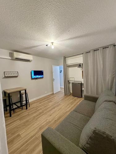 un salon avec un canapé et une table dans l'établissement Appartement 50m2, Montpellier Ovalie, clim-balcon-netflix, à Montpellier