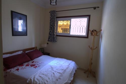 ein Schlafzimmer mit einem Bett und einem Fenster in der Unterkunft Seaside House in Imsouane