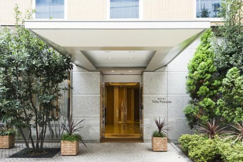 an entrance to a building with awning and plants at Hotel Villa Fontaine Tokyo-Hamamatsucho in Tokyo